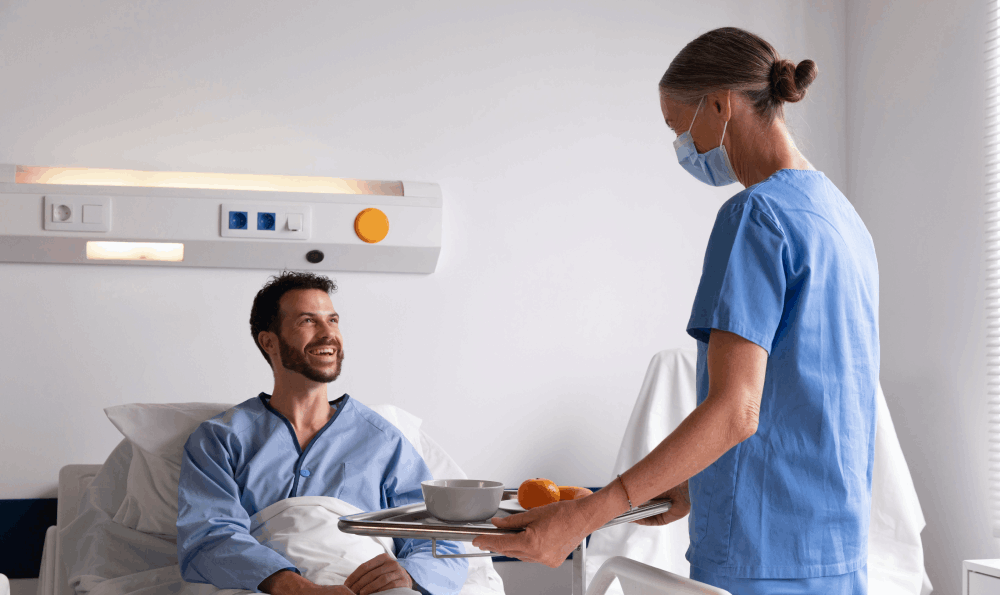 Nurse serving food to a patient in sri chakra hospital room in Chennai showing compassionate healthcare